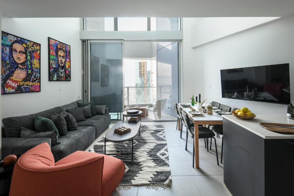 sala de estar con sofá y comedor en Luxury 3BR Duplex with Sea View in Tel-Aviv Center by Sea N' Rent en Tel Aviv