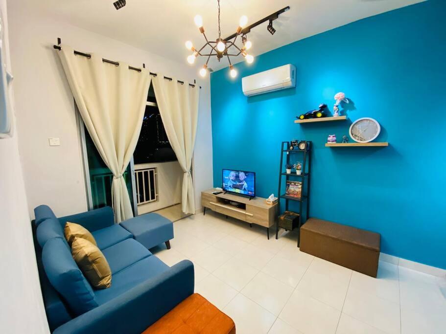 a blue living room with a blue wall at Cozy 3BR Apartment with Free Netflix in Bayan Lepas