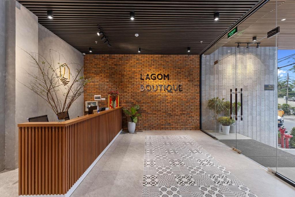 峴港的住宿－Lagom Boutique Hotel Da Nang，大堂设有前台和砖墙