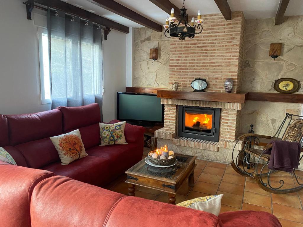 a living room with a couch and a fireplace at Alojamiento Cerro Socorro in Cuenca