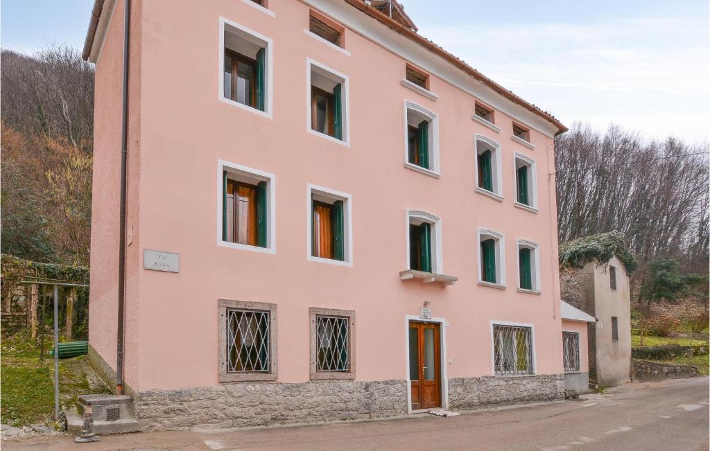un bâtiment rose avec de nombreuses fenêtres sur une rue dans l'établissement Nice Home In Lusiana With Kitchen, à Lusiana