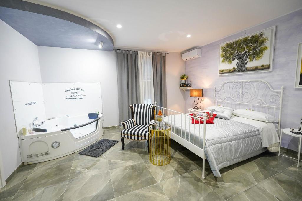 a bedroom with a bed and a bath tub and a sink at Piedigrotta b&b Luxury in Pizzo