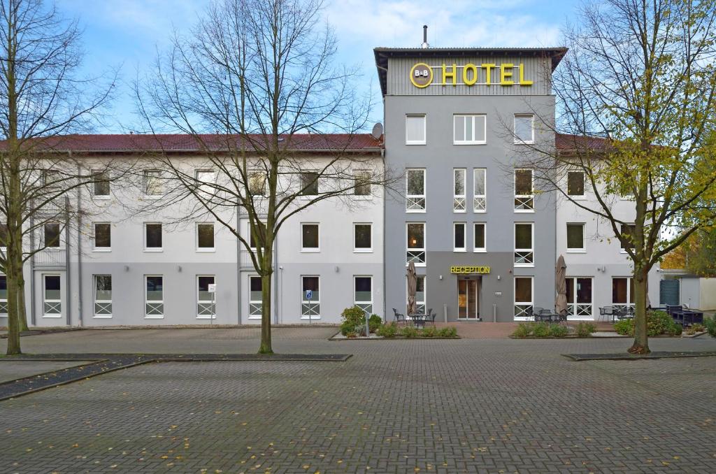 ein großes weißes Gebäude mit Hotelschild drauf in der Unterkunft B&B Hotel Düsseldorf-Ratingen in Ratingen