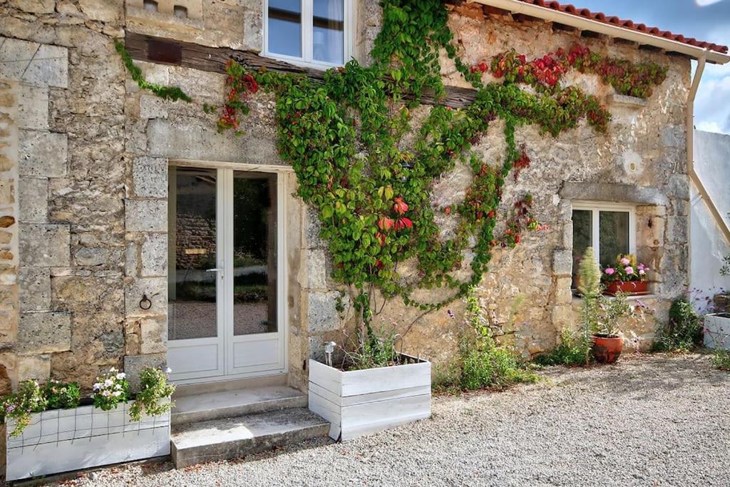 ein Steingebäude mit Blumen auf der Seite in der Unterkunft Maison d'Amis Des Hirondelles in Lempzours
