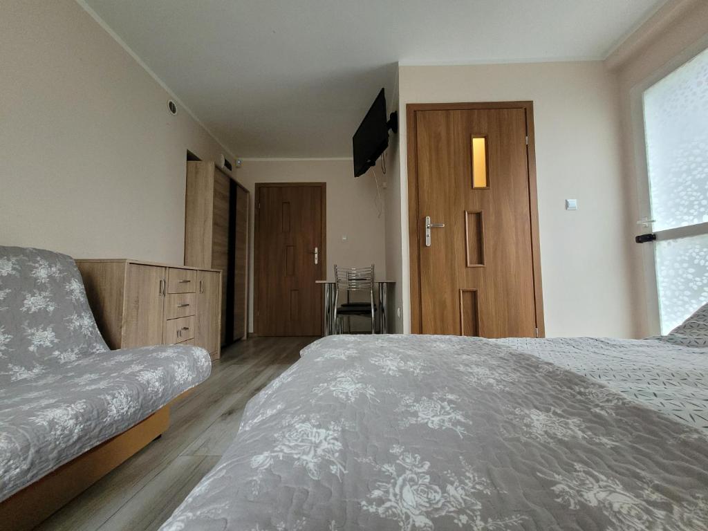 1 dormitorio con 1 cama y TV en Przy Deptaku, en Mielno
