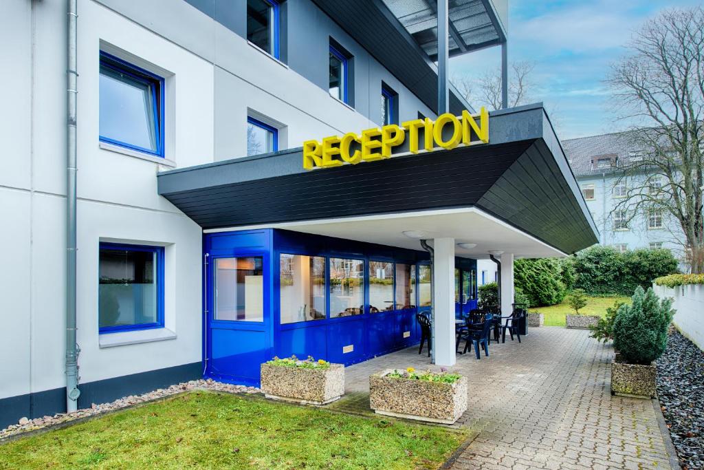 un restaurant avec un panneau bleu et jaune sur un bâtiment dans l'établissement B&B Hotel Bielefeld-Ost, à Bielefeld