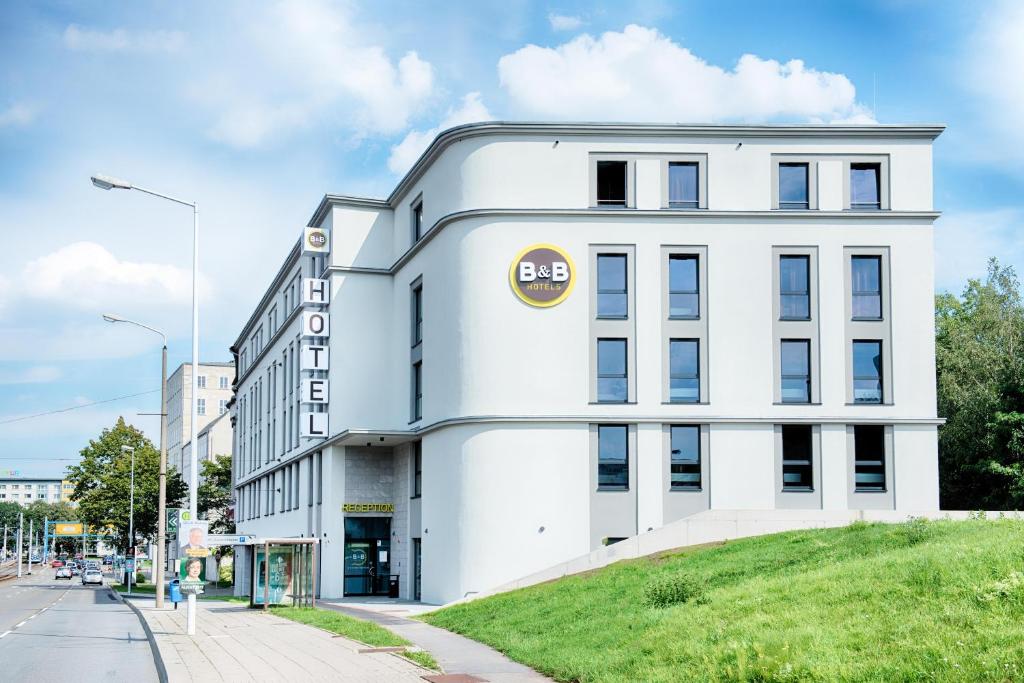 ein großes weißes Gebäude in einer Stadtstraße in der Unterkunft B&B Hotel Chemnitz in Chemnitz