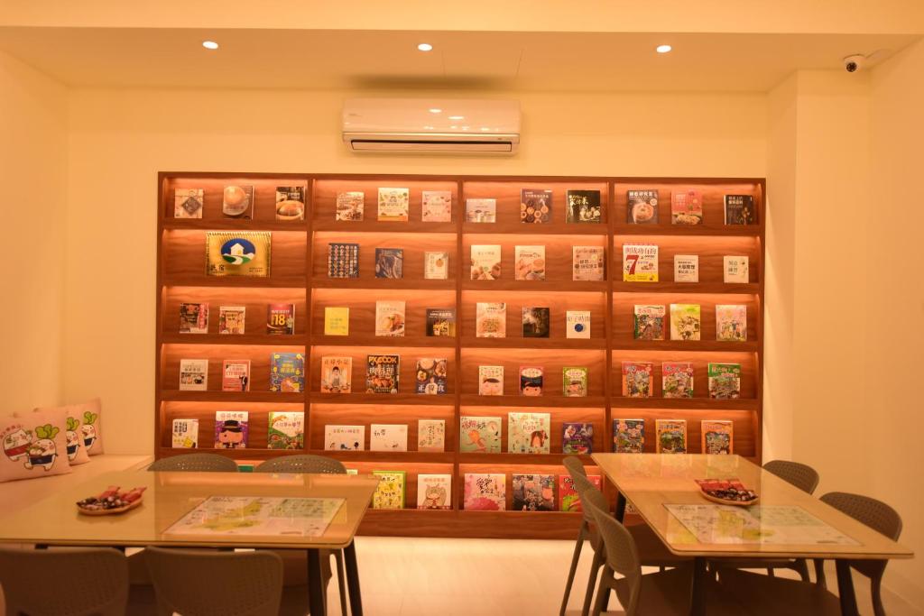 two tables in front of a wall with books at 關山棧民宿 in Guanshan