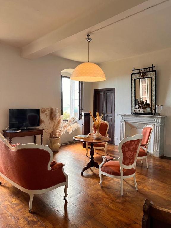 a living room with chairs and a table and a couch at Maison d'Americains Lapedina in Pietracorbara