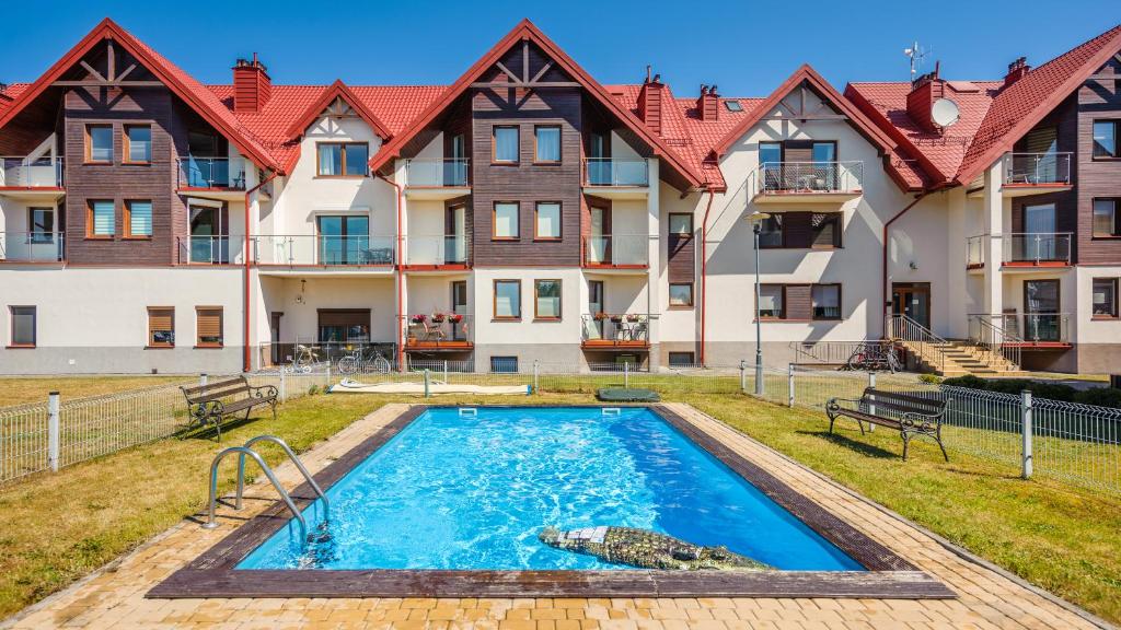 a swimming pool in front of a building at Apartamenty Sun & Snow Lisi Jar in Jastrzębia Góra