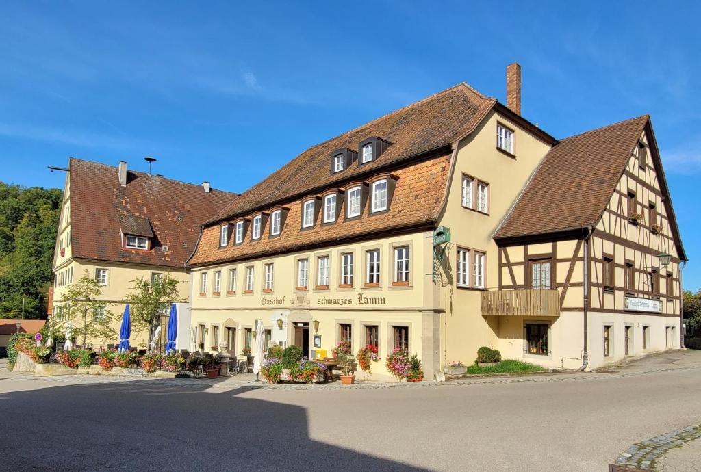 ein großes weißes Gebäude mit braunem Dach in der Unterkunft Schwarzes Lamm in Rothenburg ob der Tauber