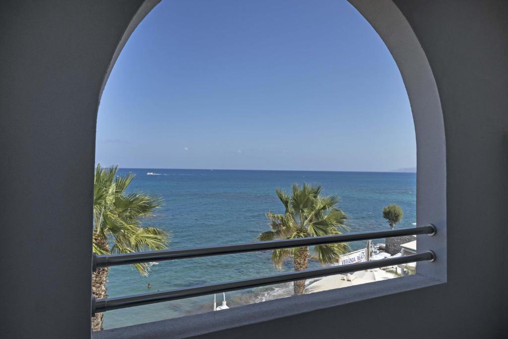 an arched window with a view of the ocean at Glaros Beach Hotel in Hersonissos