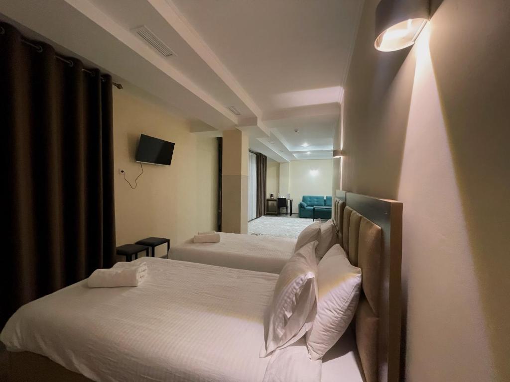 um quarto de hotel com duas camas e uma televisão em Hotel Nova em Bishkek