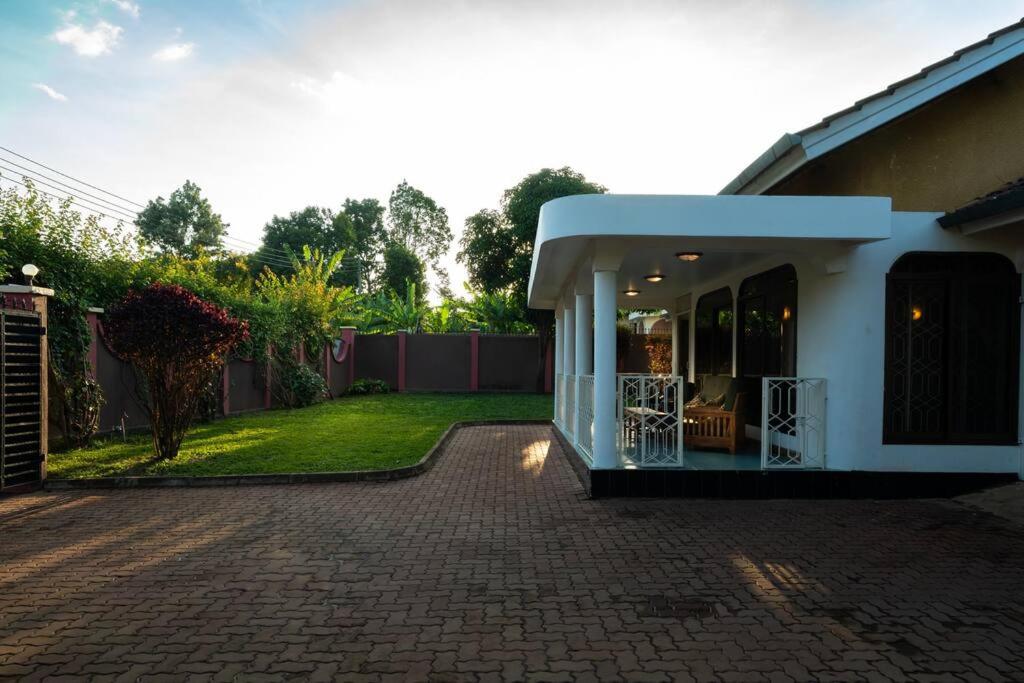 a house with a patio and a yard at Dreamer's Holiday Home Arusha in Arusha