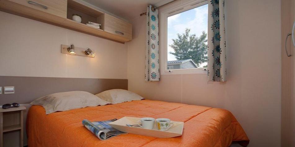- une chambre avec un lit et un plateau avec des tasses dans l'établissement Camping La Montagne, à Sorgues