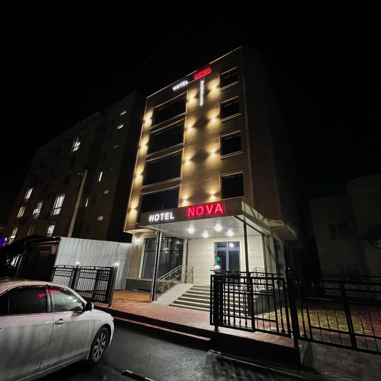 un edificio nova con un coche aparcado delante de él en Hotel Nova, en Bishkek