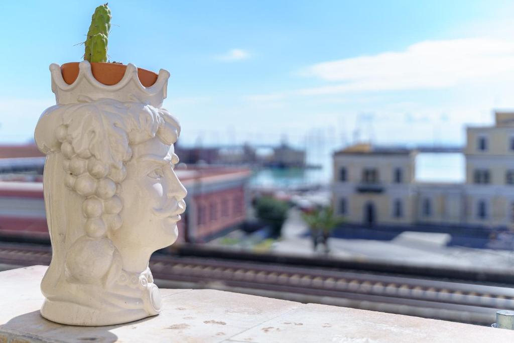 Un vaso seduto su un cornicione con vista sulla città di Sea & City Casa del Porto a Catania