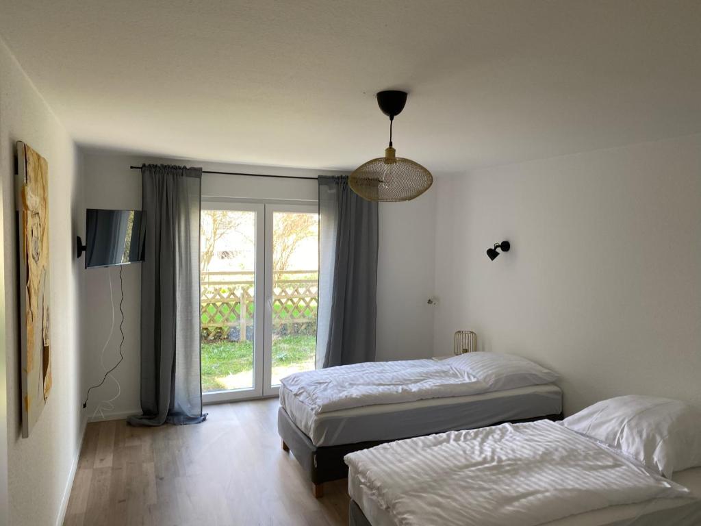 een slaapkamer met 2 bedden en een raam bij Monteurswohnung mit kleinem Garten 600M zur Stadtmitte in Siegen