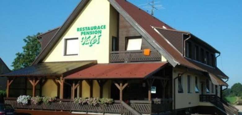 a building with a sign on the side of it at Penzion Valeš in Borovany