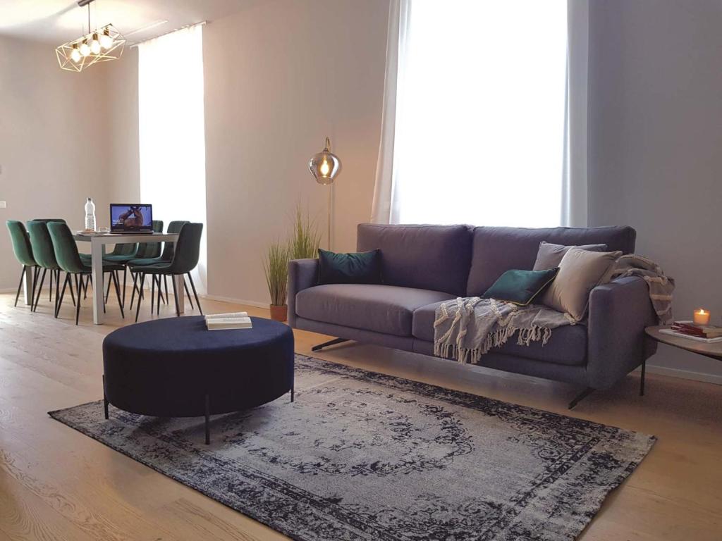 una sala de estar con un sofá y una mesa en AR Prestige Penthouse - Noho, en Bérgamo