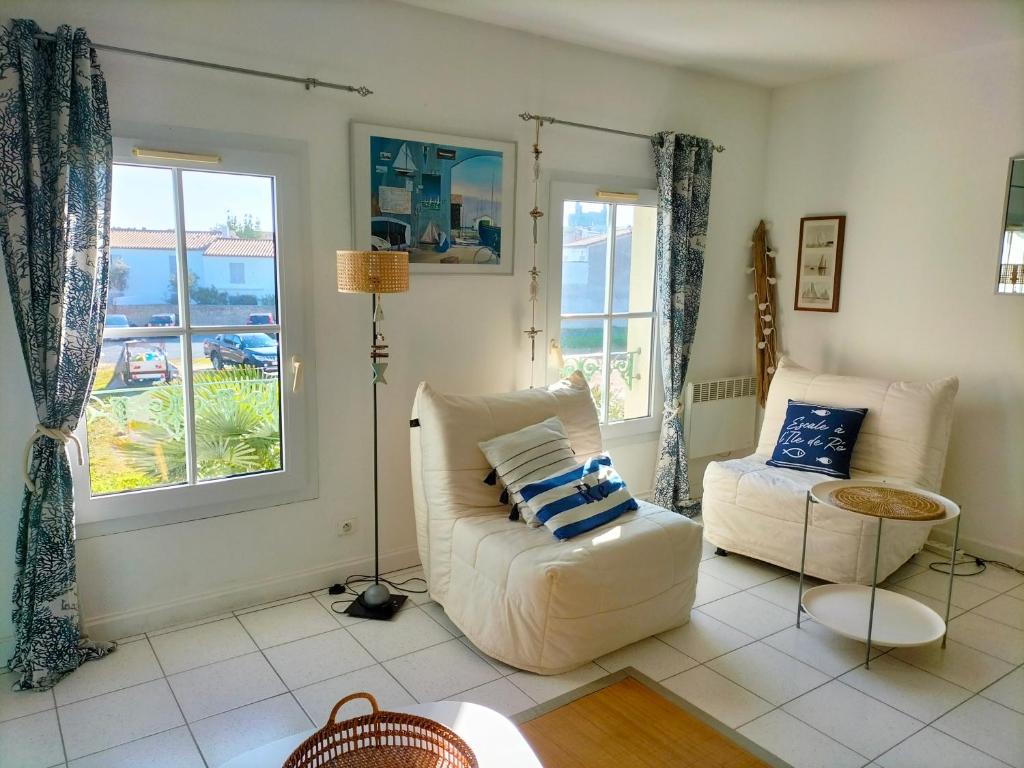 a living room with a couch and a chair at Charmant Studio à proximité du Port de St Martin de Ré in Saint-Martin-de-Ré