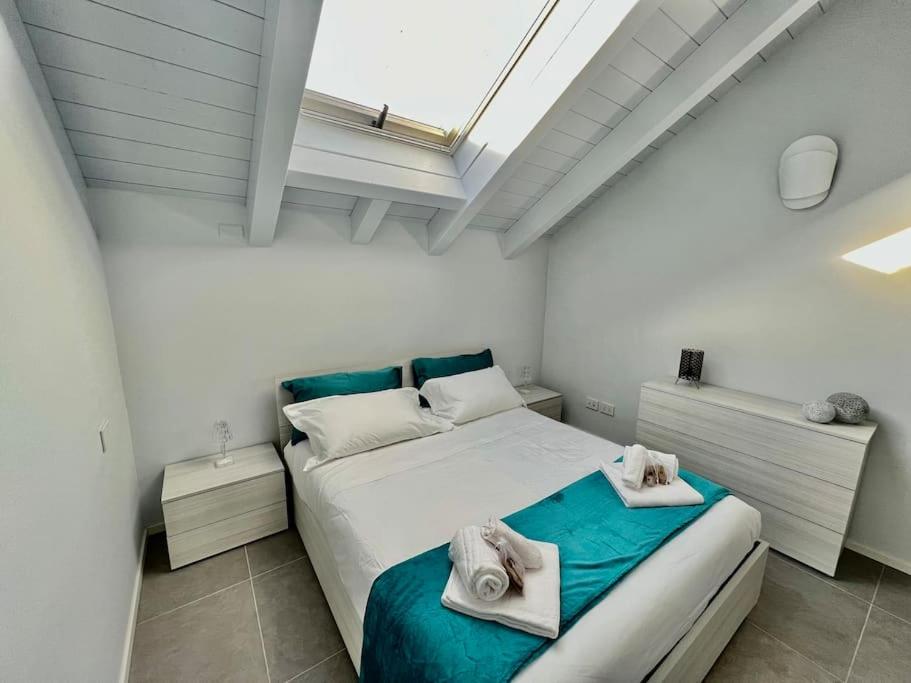 una camera da letto con un letto e asciugamani di Prestigioso attico a passo Duomo by Revenue House a Casale Monferrato