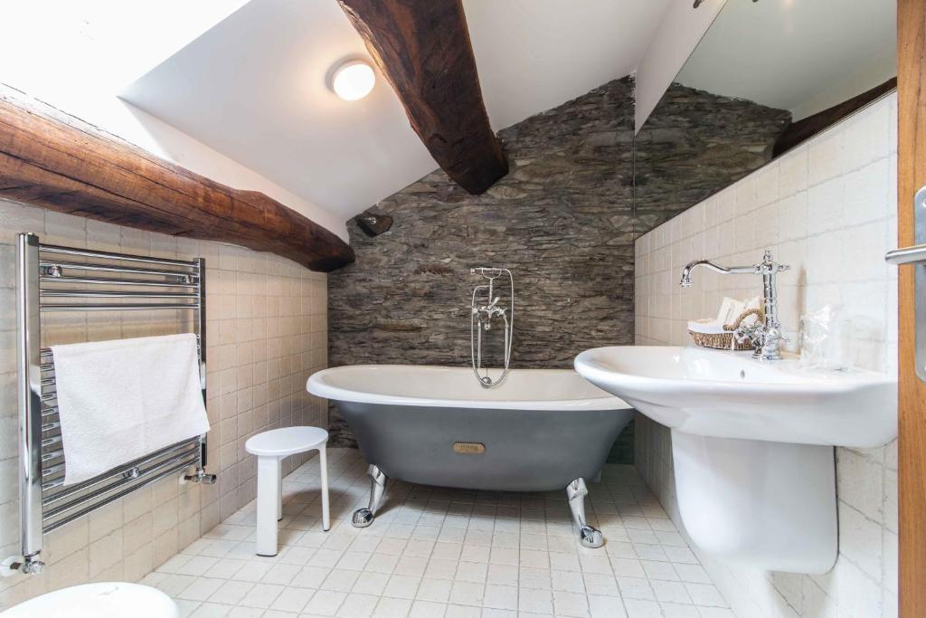 y baño con bañera y lavamanos. en Apartamentos Rurales Sierra, en Palacio de Naviego