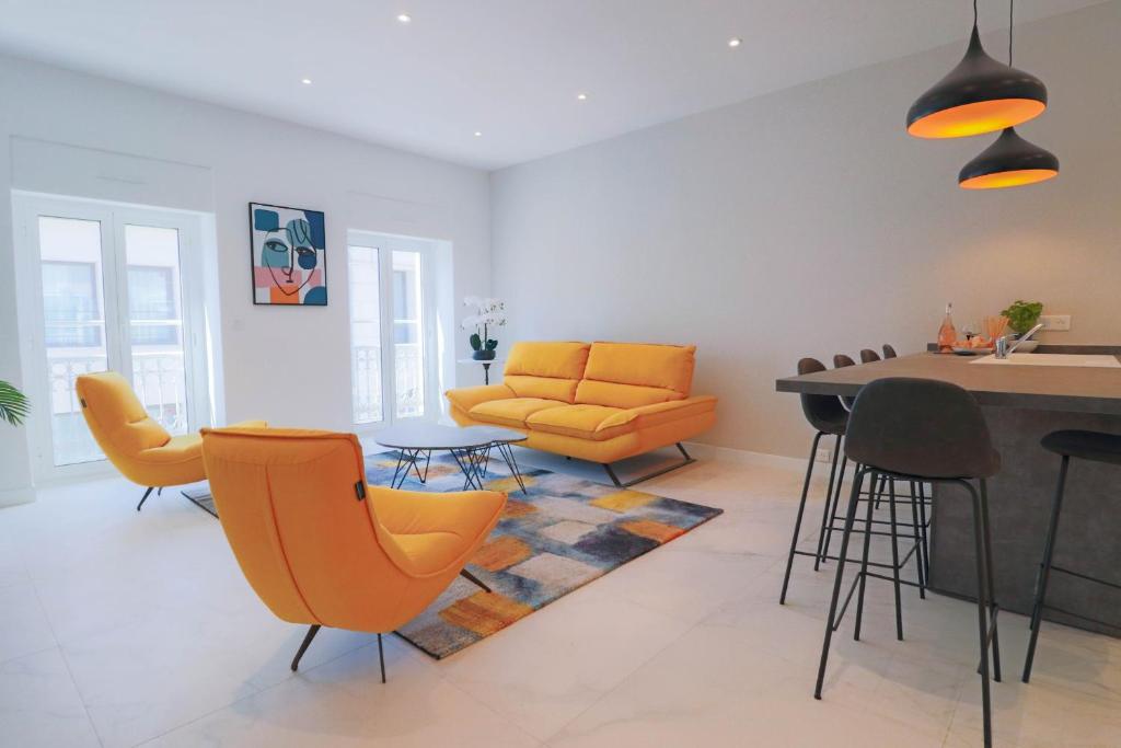 un salon avec des chaises orange et une table dans l'établissement NAPOLEON Luxurious renovated apartment 1min from Palais, à Cannes