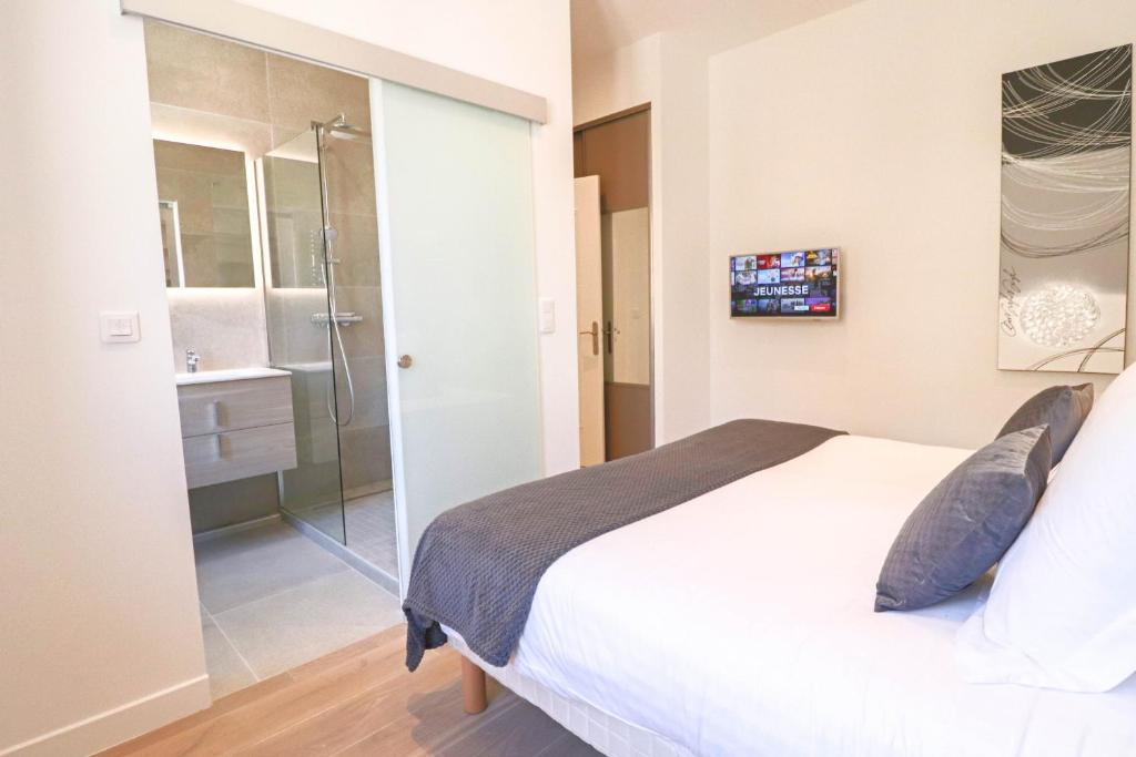 a bedroom with a shower and a white bed at NAPOLEON Luxurious renovated apartment 1min from Palais in Cannes