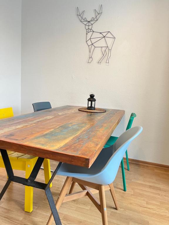 a dining room table with chairs and a deer head on the wall at Der Schwan 7 - 2 Balkone - zentral - 100 qm in Düren - Eifel
