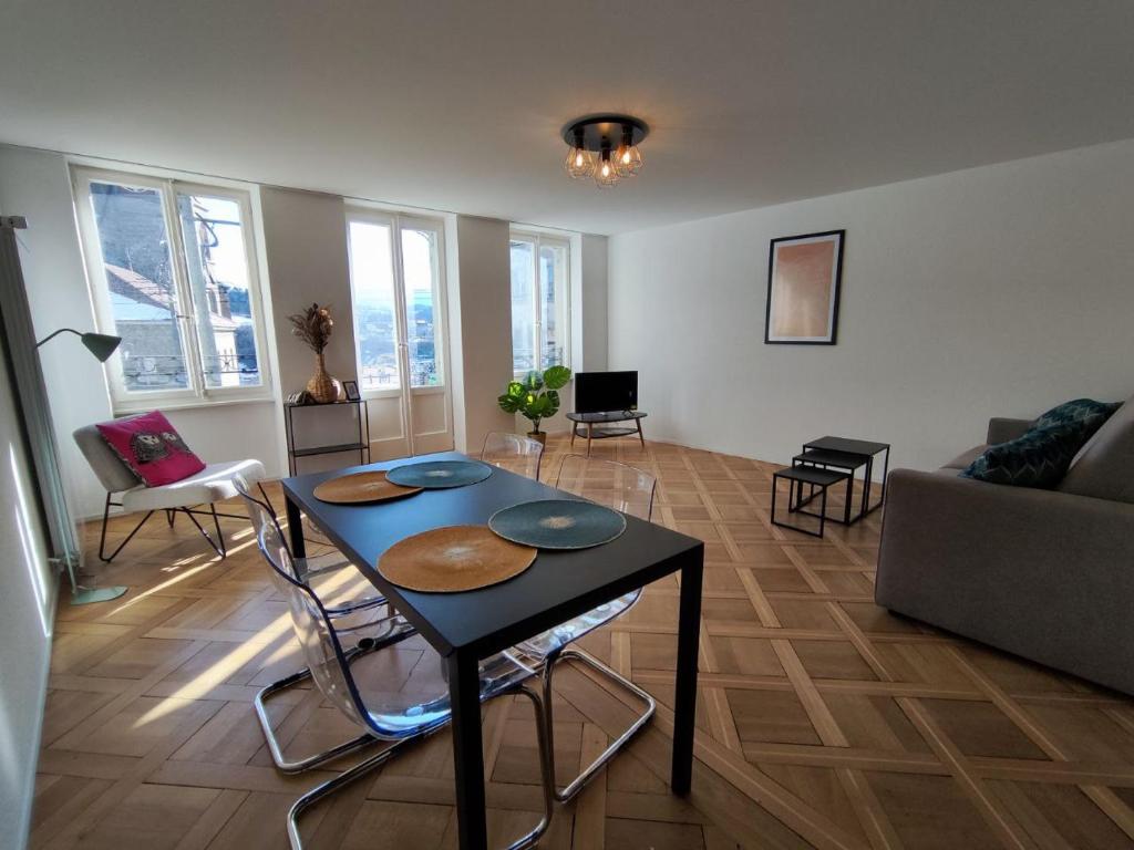 sala de estar con mesa, sillas y sofá en Appartement tout confort rénové avec vue - Tilleul 5, en Fribourg