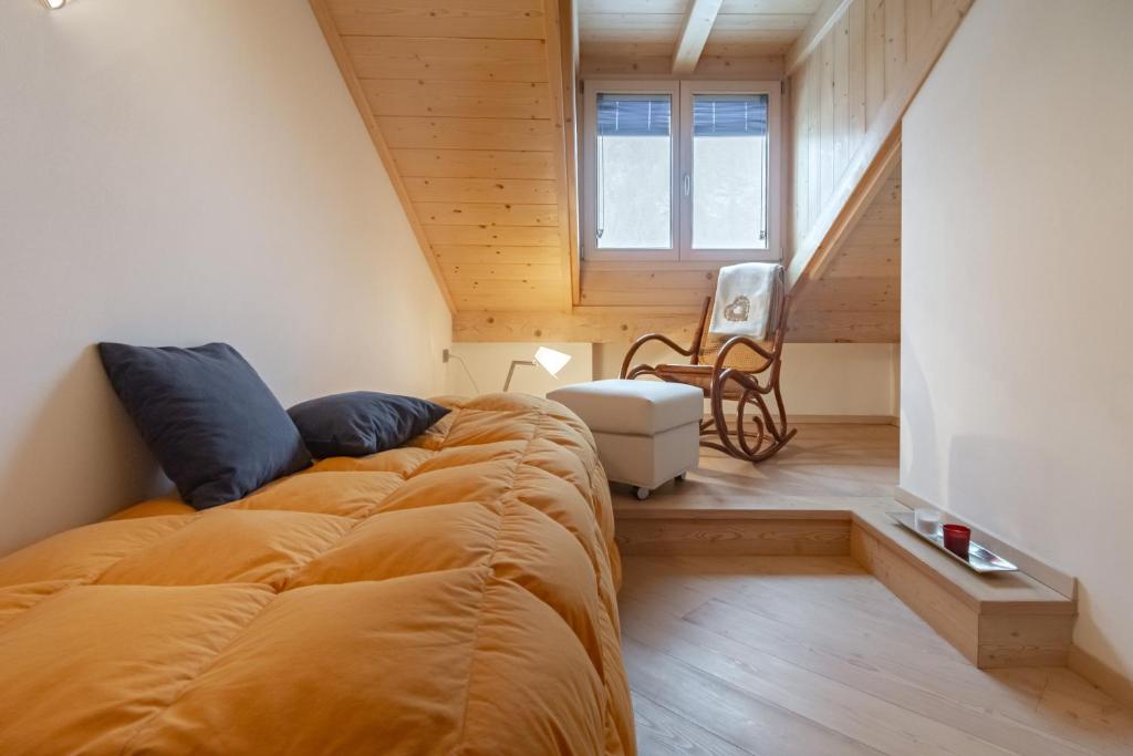 1 dormitorio con 1 cama grande y una escalera en DolomiApartments - Appartamento Orso Bruno, en Predazzo