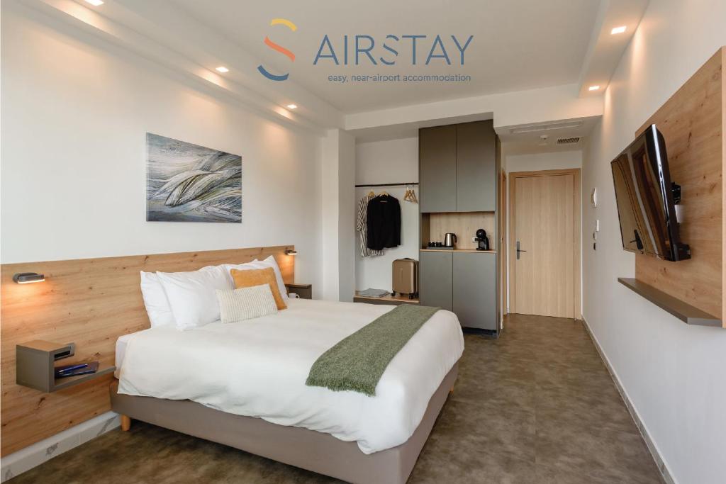 a bedroom with a large bed and a kitchen at Zed Smart Property by Airstay in Spata