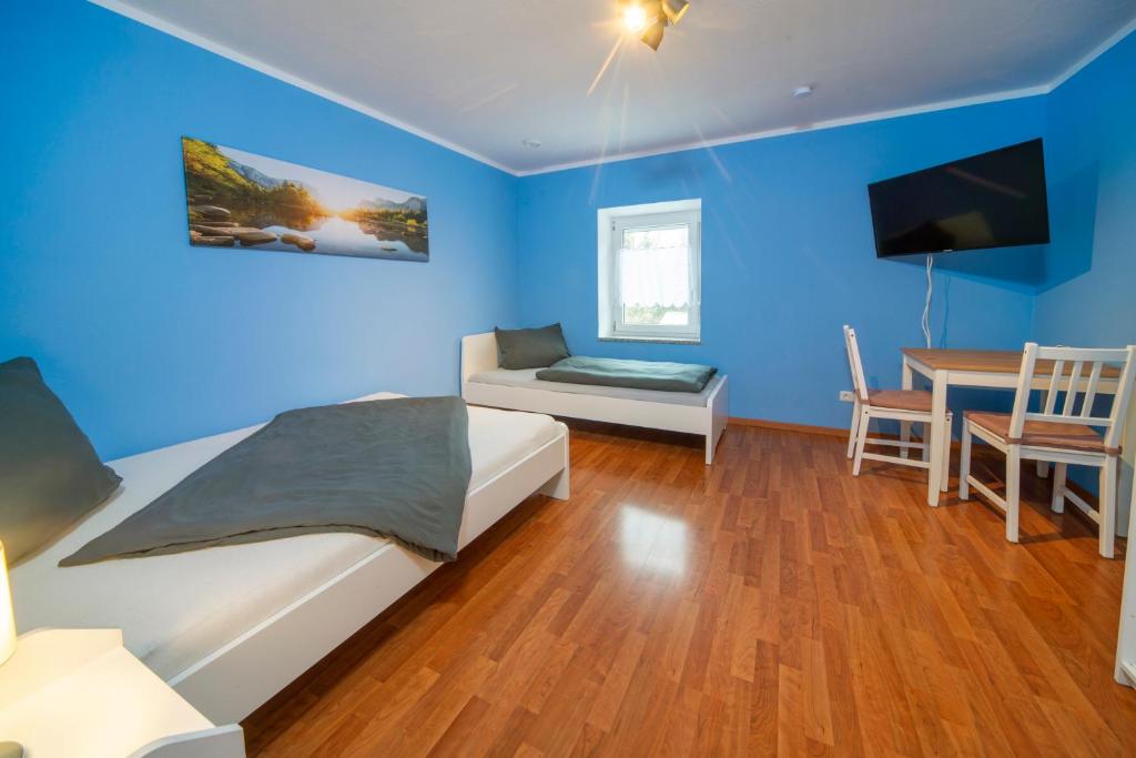 a bedroom with blue walls and a bed and a table at Apartment - Wohnung Memmingen Nr. 3 in Memmingen