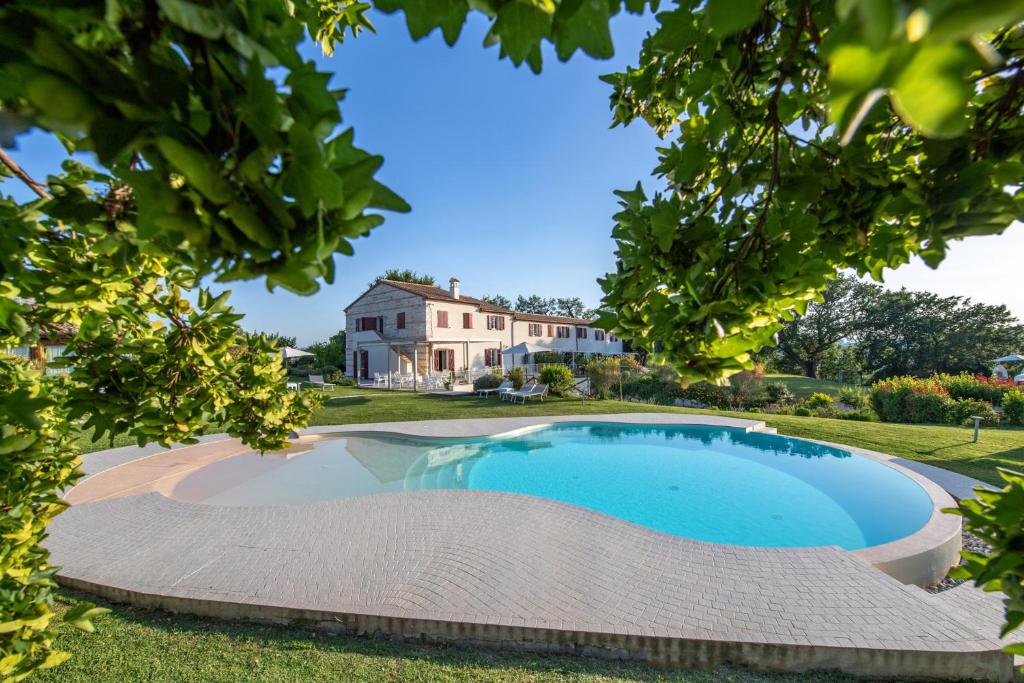 una piscina in un cortile con una casa sullo sfondo di Agromarino a Sirolo