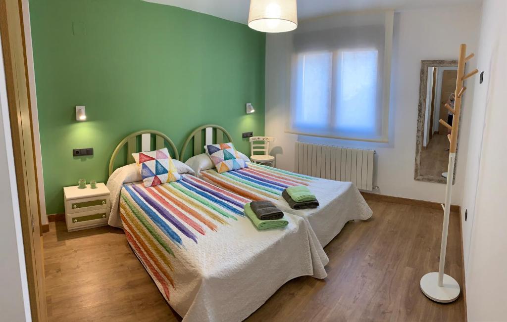 Casa Rural Flor de jara في Trabazos: غرفة نوم مع سرير مع بطانيات ووسائد ملونة
