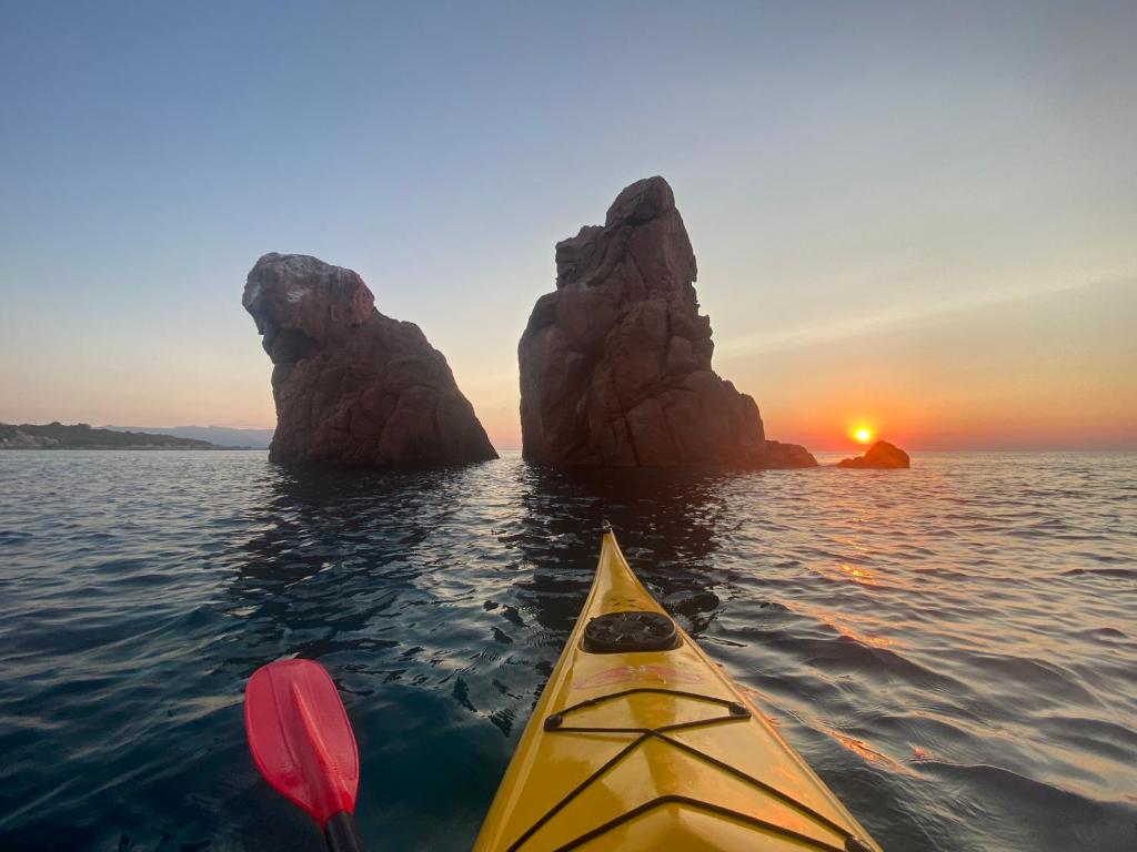 a yellow kayak in the water with a rock formation at Casa Vacanze Alba in Loceri