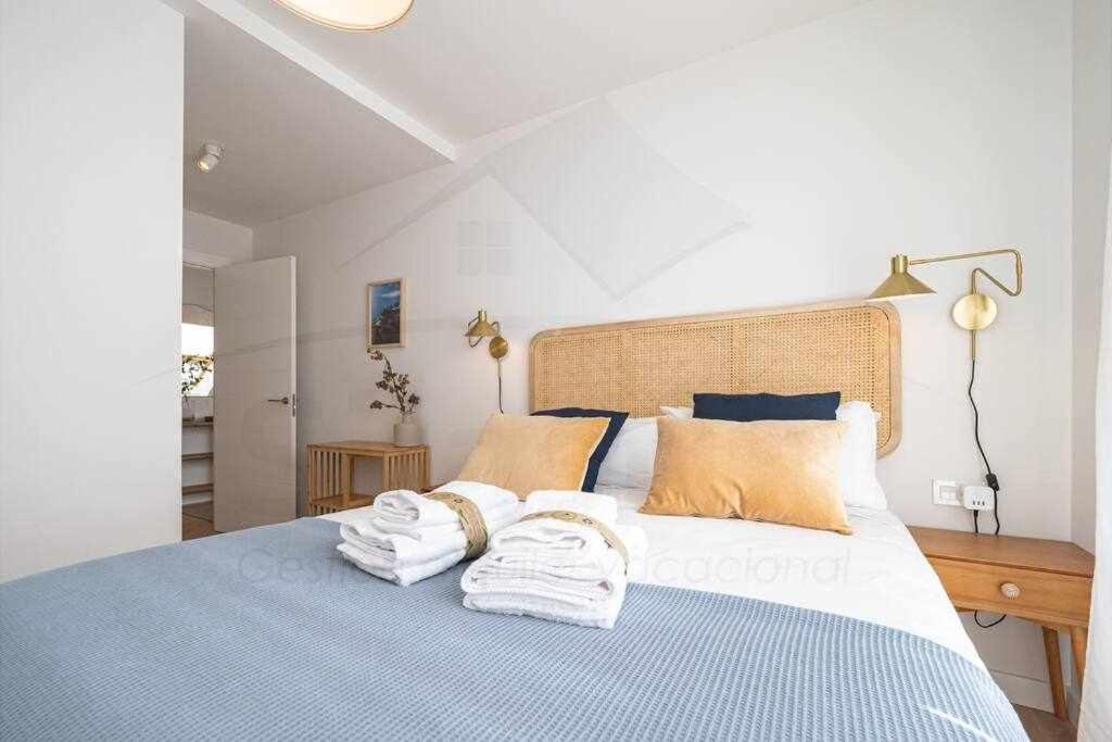 Un dormitorio con una cama azul con toallas. en La Atalaya de Xixón, en Gijón