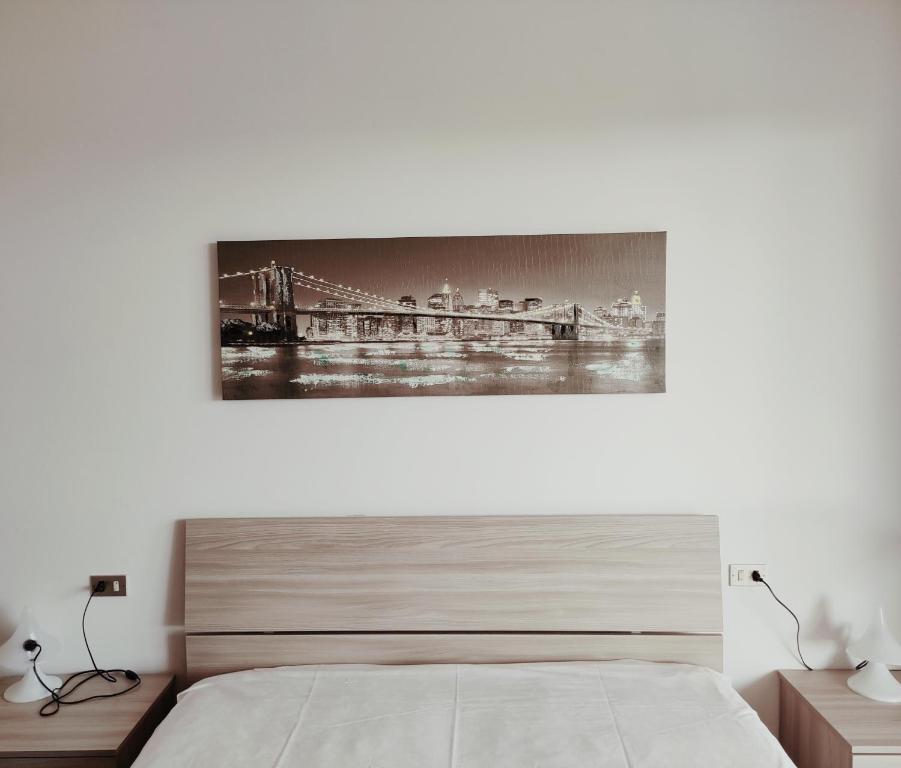 a bedroom with a bed with a painting on the wall at La terrazza sul mare in Cesenatico