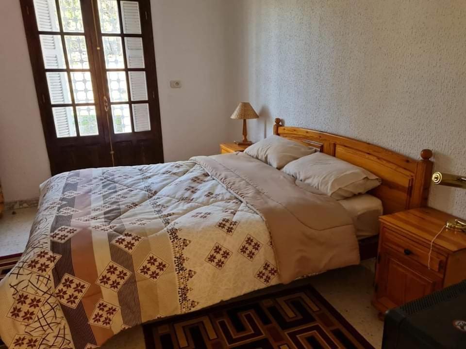 ein Schlafzimmer mit einem Bett mit einer Decke darauf in der Unterkunft Dar Monia Aïn-Draham in Jendouba