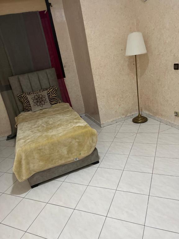 1 dormitorio con 1 cama y 1 lámpara en el suelo de baldosa en اقامة ربيعة en Casablanca