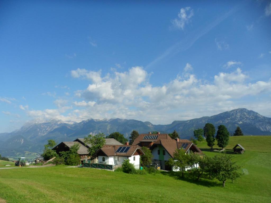 a house in a field with mountains in the background at Gruppenhaus Hirzhof in Auberg