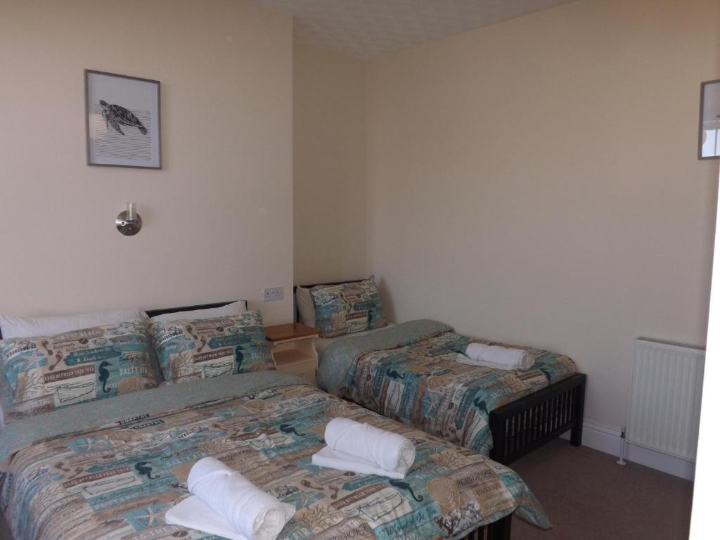 two beds in a room with two beds sidx sidx sidx at The Edenhurst Guesthouse in Weymouth