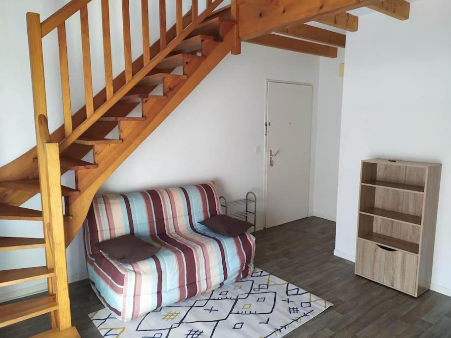 ein Wohnzimmer mit einer Treppe und einer Couch in der Unterkunft Duplex T2 proche bord de mer Quartier des Minimes in La Rochelle