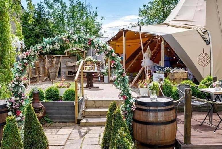 a garden with a barrel and a tent at Pear Tree Cottage in Bishop Auckland