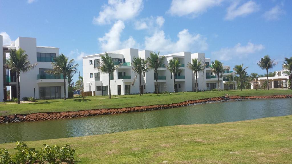 um grande edifício branco ao lado de uma massa de água em Apartamento Iberostate Mediterrâneo na Praia do Forte