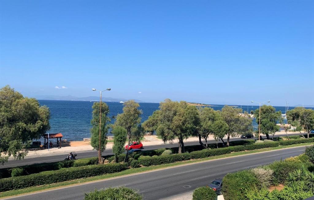a road next to the ocean with trees and a street at Galini Palace in Athens