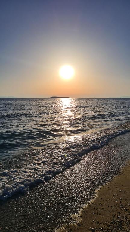 a sunset on a beach with the ocean at Galini Palace in Athens