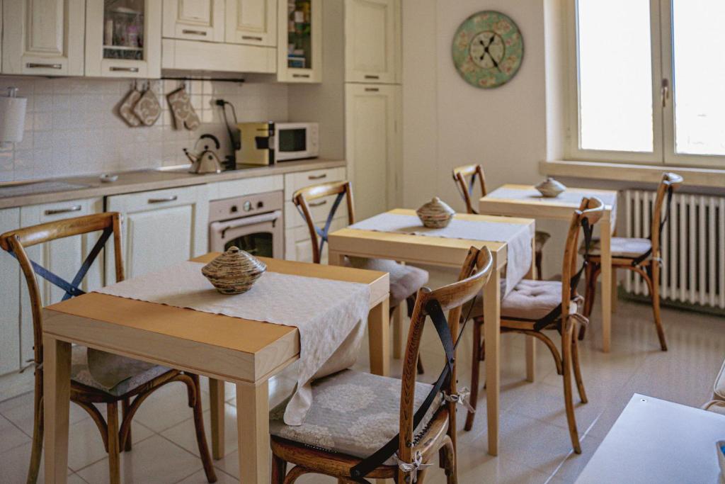 a kitchen with two tables and chairs and a kitchen with a stove at S'ARD Guest House Sassari in Sassari