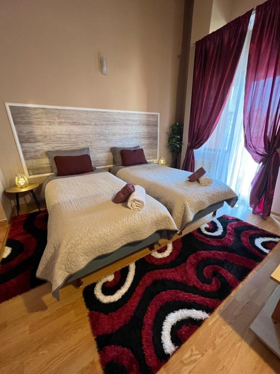 two beds in a bedroom with a rug at PENSIUNEA UNO in Timişoara